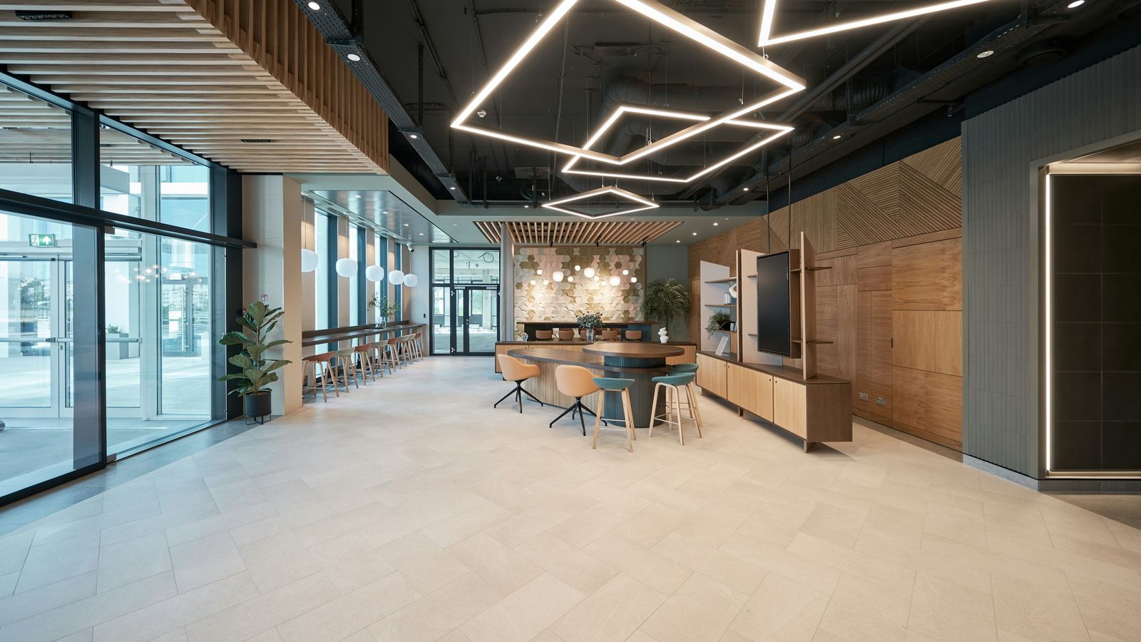 Modern office interior with glass walls, light wood and geometric ceiling lights